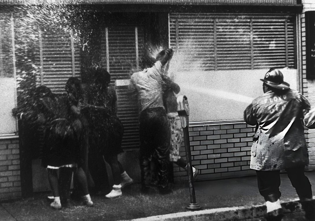 Young African American protesters being sprayed by a powerful fire hose in 1963 Birmingham, Alabama