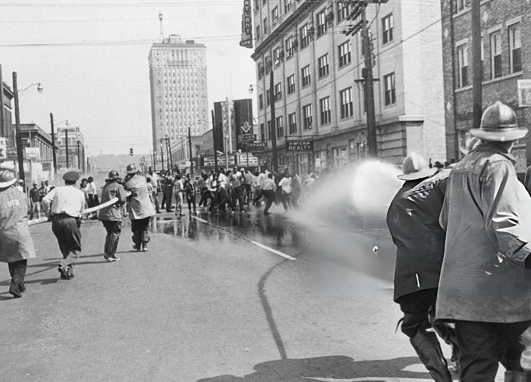 Firemen spraying African American protestors in Birmingham, Alabama, during the Civil Rights Movement